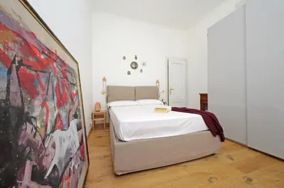 a white bed in a room with a painting at Cozy Esquilino - My Extra Home in Rome