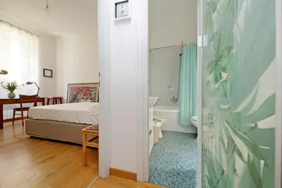 a bedroom with a bed and a bathroom with a tub at Cozy Esquilino - My Extra Home in Rome