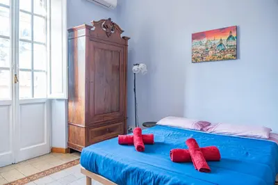 two red stuffed animals sitting on top of a blue bed at Lion Renting Metro Piramide in Rome