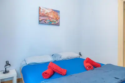 a blue bed with red pillows on top of it at Lion Renting Metro Piramide in Rome