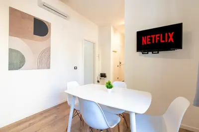 a white dining room with a white table and chairs at Central Modern Apartment - Colosseo 10 min in Rome