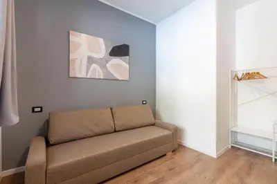 a couch in a room with a painting on the wall at Central Modern Apartment - Colosseo 10 min in Rome