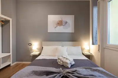a bedroom with a bed and two lamps and a picture at Central Modern Apartment - Colosseo 10 min in Rome