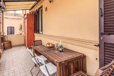 a wooden table and chairs on a patio at Pìgneto Roma Good Vibes Apartment in Rome