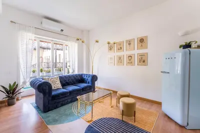 a living room with a blue couch and a refrigerator at Flaminio Blues, Cozy Flat Near Piazza del Popolo in Rome