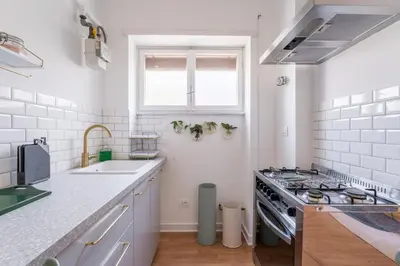 a white kitchen with a stove and a sink at Flaminio Blues, Cozy Flat Near Piazza del Popolo in Rome