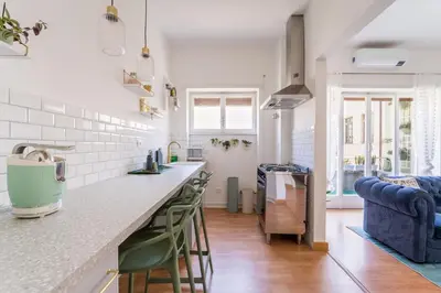 a kitchen with a counter and chairs in a room at Flaminio Blues, Cozy Flat Near Piazza del Popolo in Rome