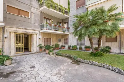 a courtyard of a building with a palm tree at Flaminio Blues, Cozy Flat Near Piazza del Popolo in Rome