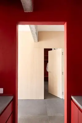 a kitchen with a white refrigerator in a red wall at Vatican Loft - Musei Vaticani in Rome