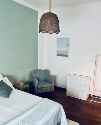 a bedroom with a bed and a chair and a lamp at Monteverde 65 in Rome