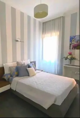 a bedroom with a bed with striped walls and a window at Piazza di Spagna Suite in Rome