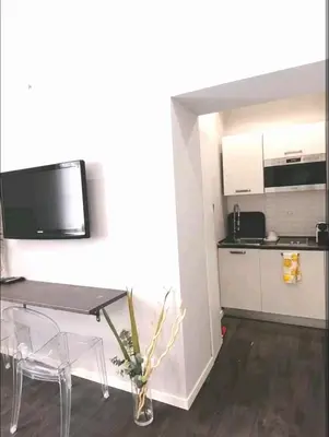 a living room with a table and a kitchen at Piazza di Spagna Suite in Rome