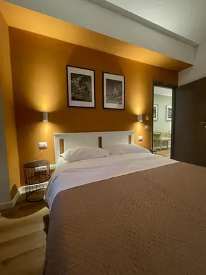 a bedroom with a large bed with two pictures on the wall at Maison Adelaide in Rome