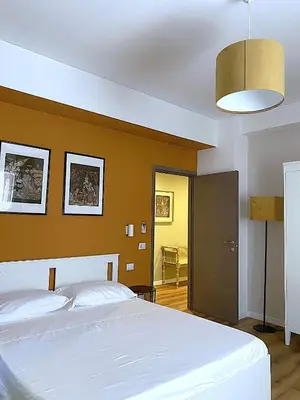 a bedroom with a white bed and a brown wall at Maison Adelaide in Rome