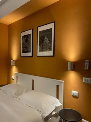 a bedroom with a white bed and two pictures on the wall at Maison Adelaide in Rome