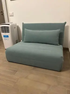 a bed with a pillow next to a heater at Lovely apartment in the center of Rome, Monti in Rome