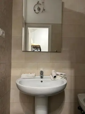 a white sink in a bathroom with a mirror at Lovely apartment in the center of Rome, Monti in Rome