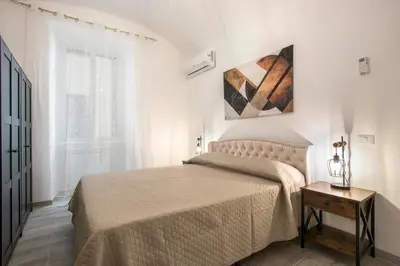a white bedroom with a bed and a table at Design Flat - Nel Centro di Roma in Rome