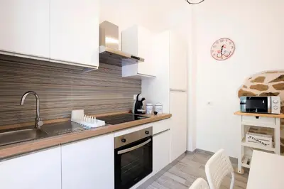 a kitchen with white cabinets and a sink at Design Flat - Nel Centro di Roma in Rome