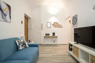 a living room with a blue couch and a tv at Design Flat - Nel Centro di Roma in Rome