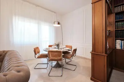 a dining room with a table and chairs and a couch at Elegante appartamento con 3 Camere da letto vicino il Centro in Rome