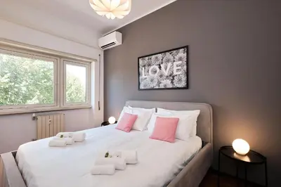 a bedroom with a large white bed with pink pillows at Elegante appartamento con 3 Camere da letto vicino il Centro in Rome