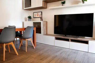 a living room with a television and a table and chairs at Washington TownHouse - Roma Statuto in Rome
