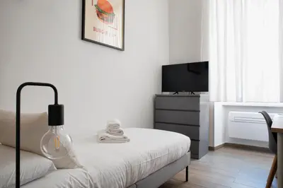 a white bedroom with a bed and a tv at Washington TownHouse - Roma Statuto in Rome