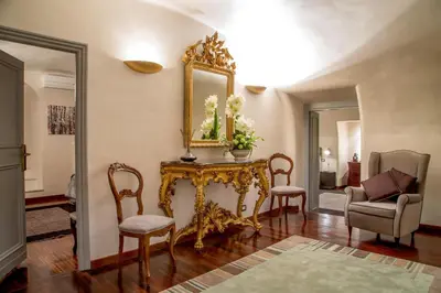 a living room with a table and chairs and a mirror at Palazzo De Cupis - Suites and View in Rome