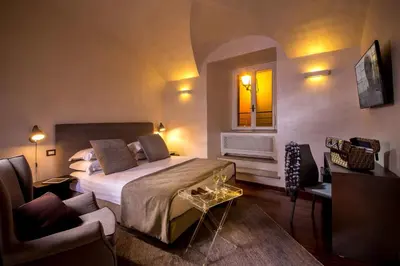 a bedroom with a bed and a chair and a window at Palazzo De Cupis - Suites and View in Rome