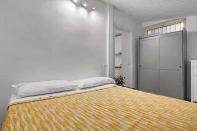 a bedroom with a large bed with a yellow blanket at Cavour 172 - Monti Apartment near Colosseum by RHR in Rome