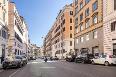 a city street with parked cars and a person riding a bike at Cavour 172 - Monti Apartment near Colosseum by RHR in Rome