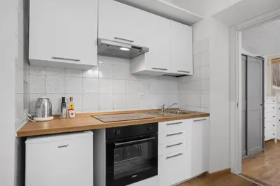 a kitchen with white cabinets and a sink and a stove at Cavour 172 - Monti Apartment near Colosseum by RHR in Rome
