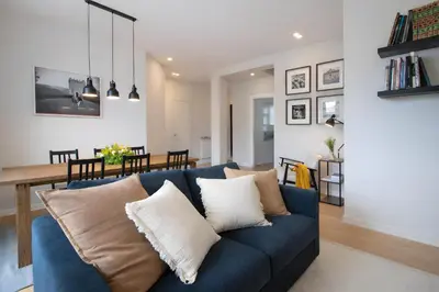 a living room and dining room with a blue couch at Sunny Monteverde Apartment - Near Trastevere by RHR in Rome
