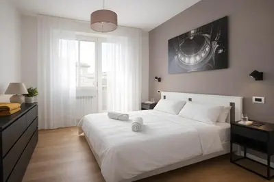 a bedroom with a white bed and a large window at Sunny Monteverde Apartment - Near Trastevere by RHR in Rome