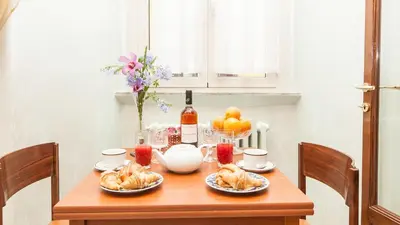 a wooden table with food and a bottle of wine at Domus Minervae in Rome