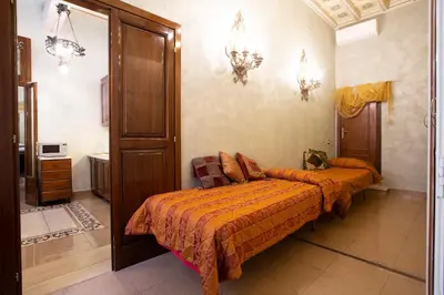 a bedroom with two beds with orange comforters at Domus Minervae in Rome