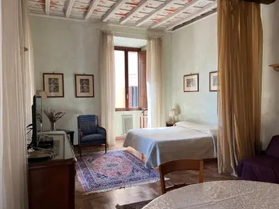 a bedroom with a bed and a chair and a window at Domus Minervae in Rome