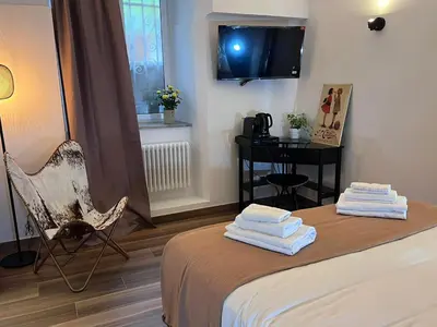 a room with a bed and a chair and a table at Giorgina Garden&Rooms in Rome