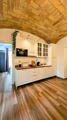 a kitchen with white cabinets and a wooden ceiling at Giorgina Garden&Rooms in Rome