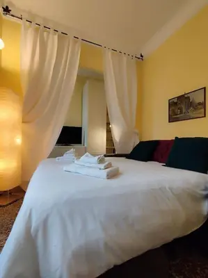 a bedroom with a white bed with white curtains at Vatican House intero appartamento in Rome