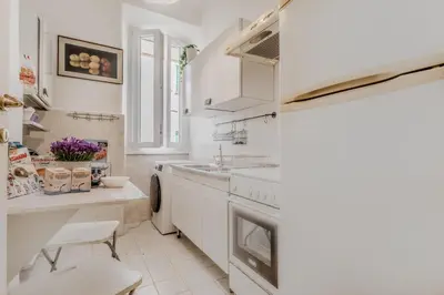 a white kitchen with a sink and a stove at Vatican House intero appartamento in Rome