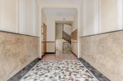 an empty hallway with a tile floor and stairs at Vatican House intero appartamento in Rome