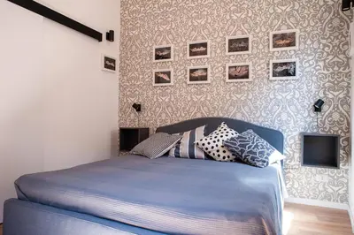 a bedroom with a blue bed with pictures on the wall at Casa Luce 66 in Rome