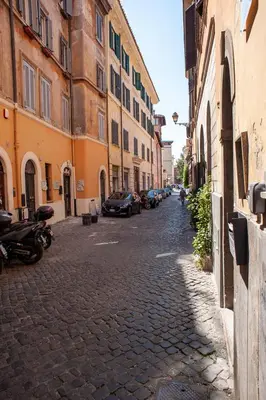 a cobblestone street with buildings and cars parked on it at Casa Luce 66 in Rome