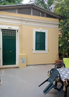 a house with a green door and a table and chairs at DELIGHTFUL LOFT IN PlGNETO in Rome