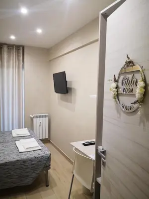 a room with a bed and a table and a tv at Gidà Room Metro B Monti Tiburtini Roma in Rome