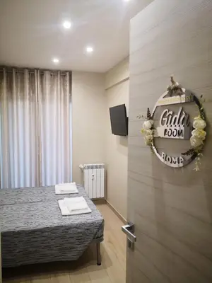 a room with a bed and a sign on the wall at Gidà Room Metro B Monti Tiburtini Roma in Rome