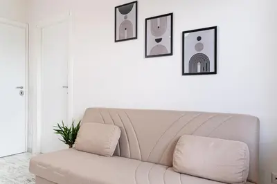 a couch in a living room with pictures on the wall at RomeCornelia Apartment - Musei Vaticani - San Pietro in Rome