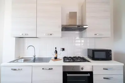 a kitchen with a sink and a stove and a microwave at RomeCornelia Apartment - Musei Vaticani - San Pietro in Rome